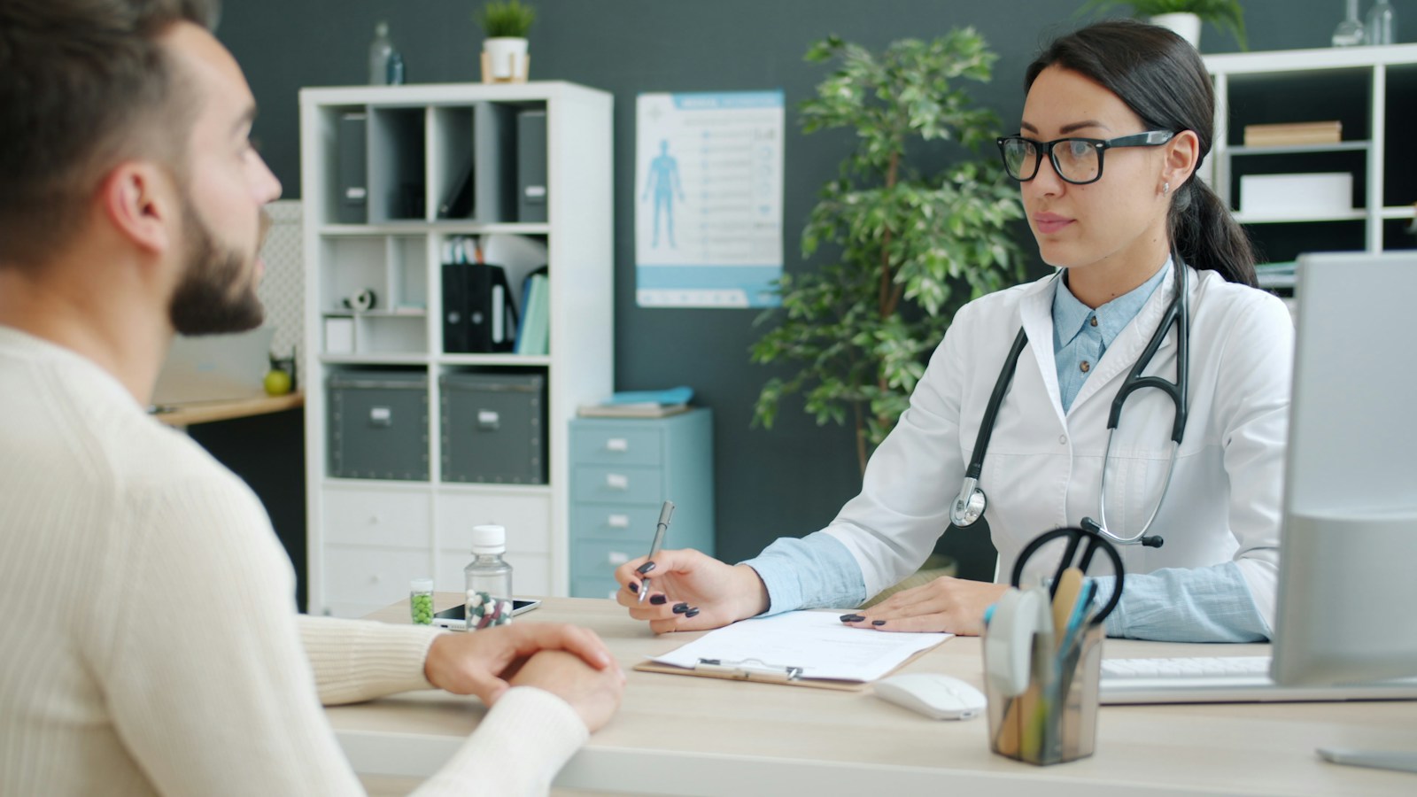 A doctor talking with a patient across her desk