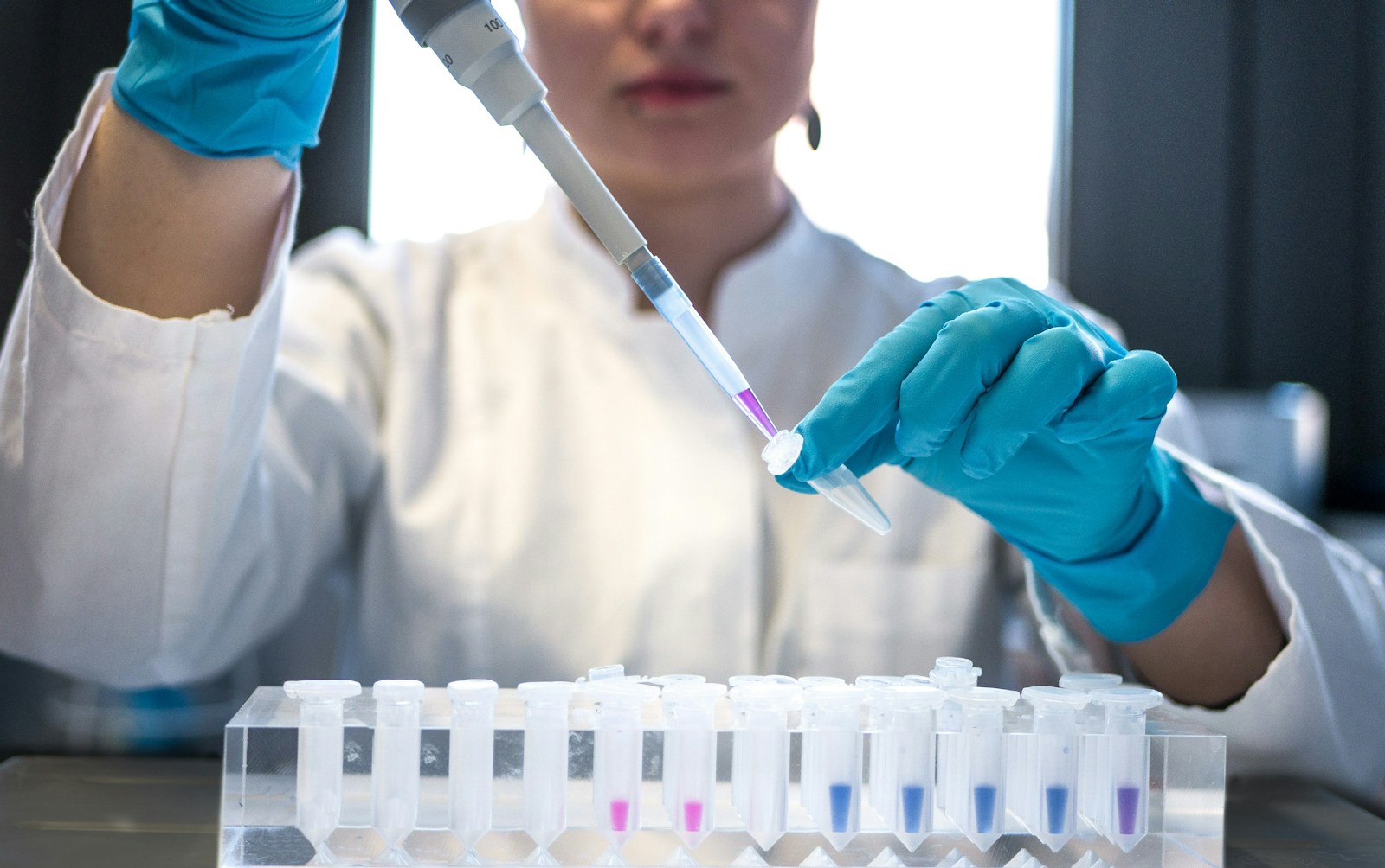 A lab technician pipetting samples into test tubes